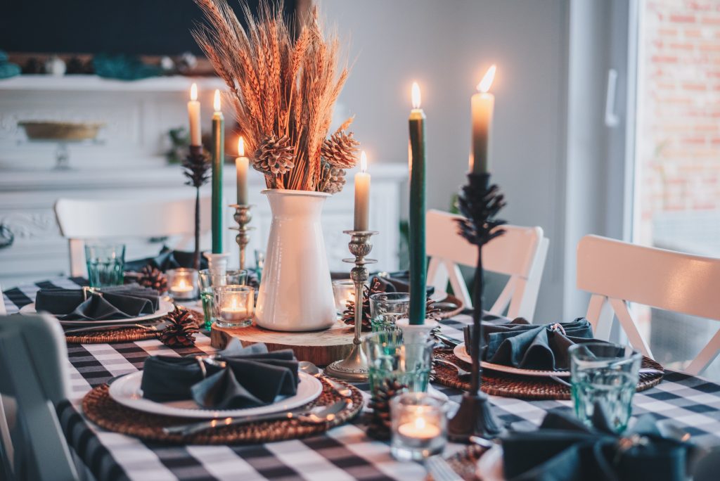 Photo of table decorated with candles and winter decorations